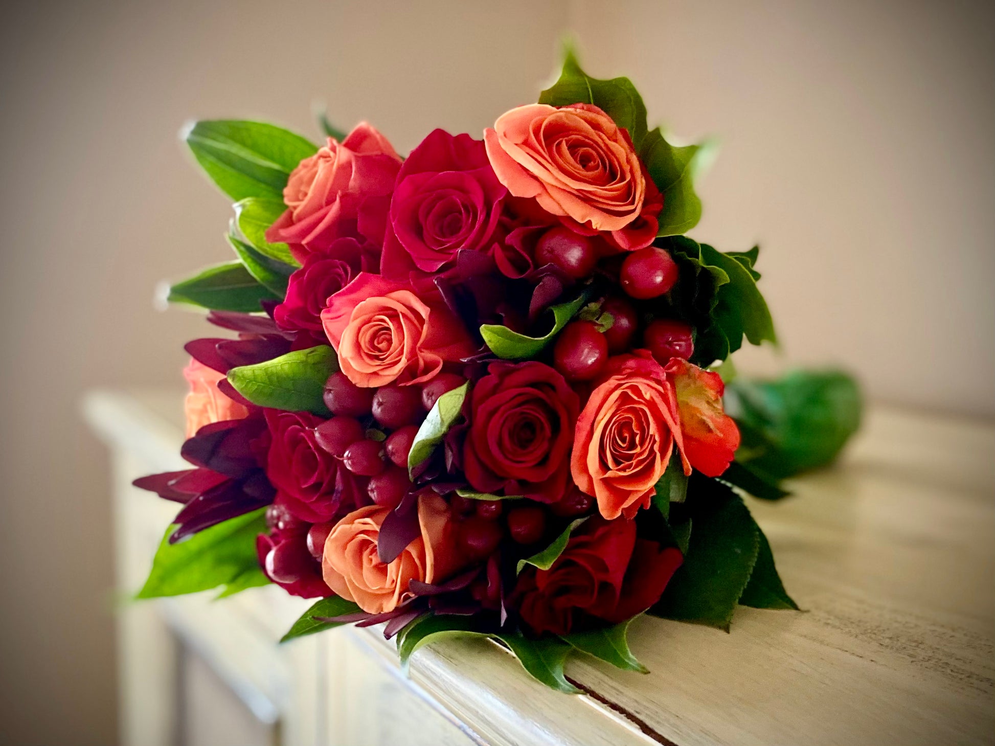 Close-up view of Harvest Dreams product featuring red and orange roses bouquet on a tabletop