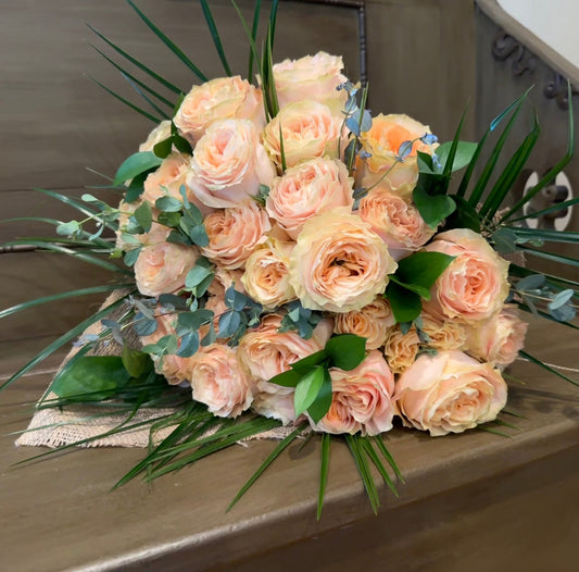 Heaven Scent product displaying a bouquet of peach roses on a rustic wooden bench